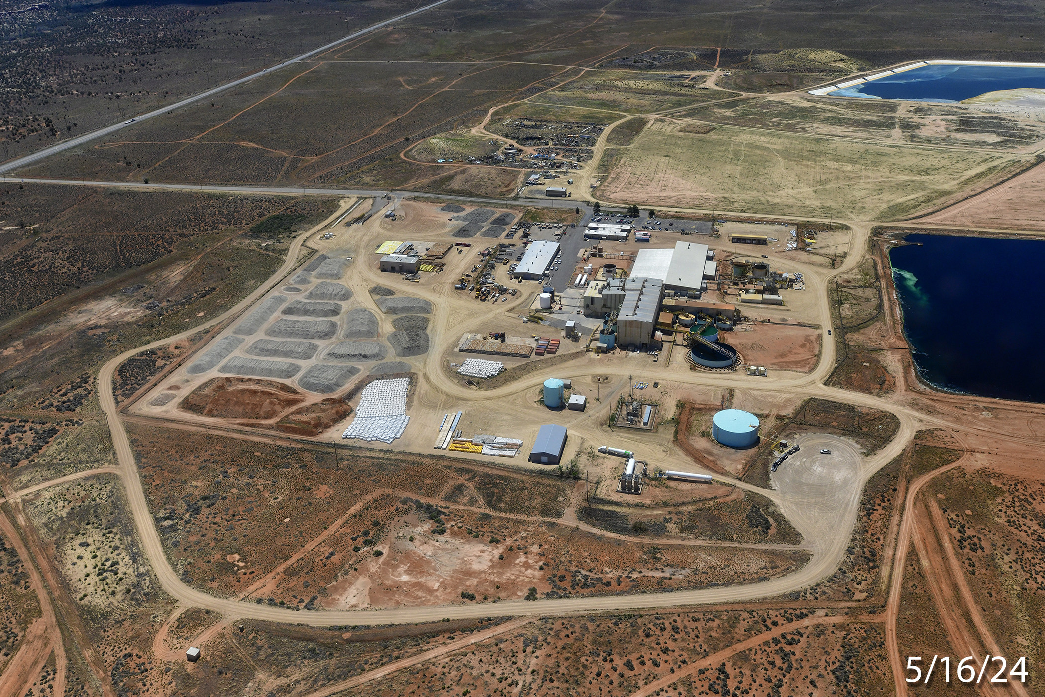 The ore pad at the White Mesa Mill on May 16, 2024. The suspected Japan Atomic Energy Agency containers can be seen at the centre bottom of the photo in a vertical white column beside the bright yellow area. Photo: Tim Peterson / EcoFlight